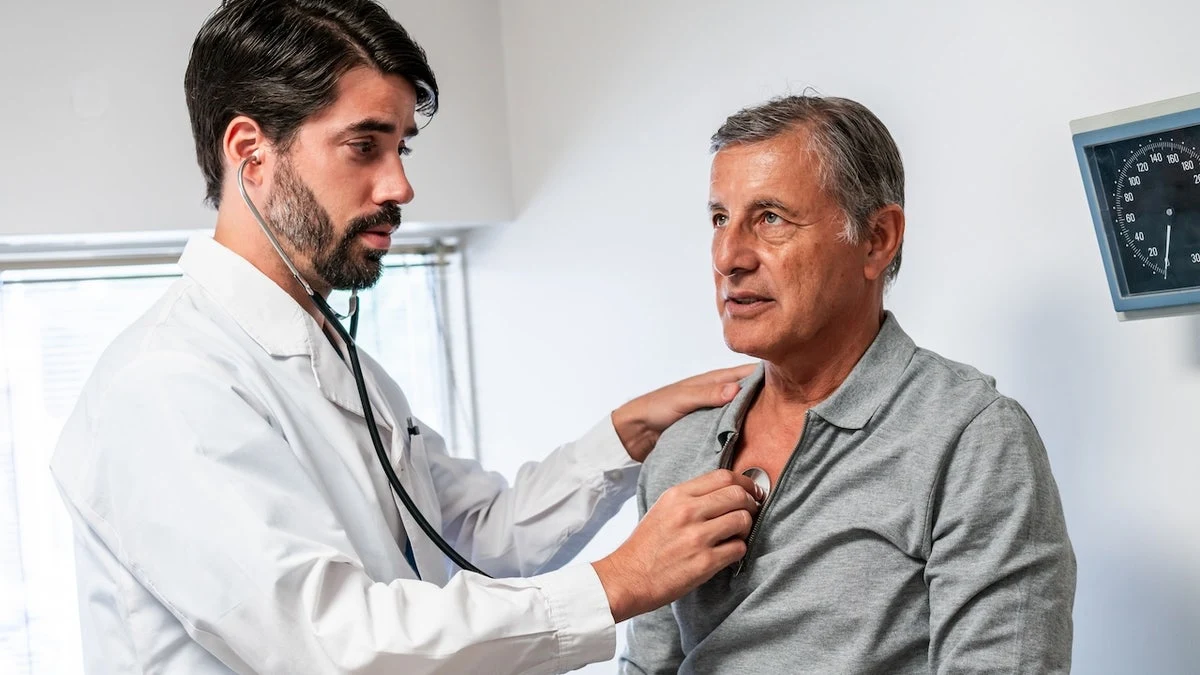 Cardiólogo auscultando a un paciente adulto