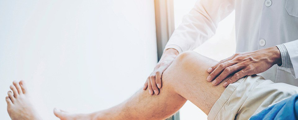 Especialista examinando la rodilla de un paciente