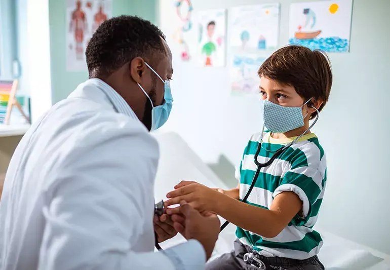 Pediatra atendiendo a un niño en consulta